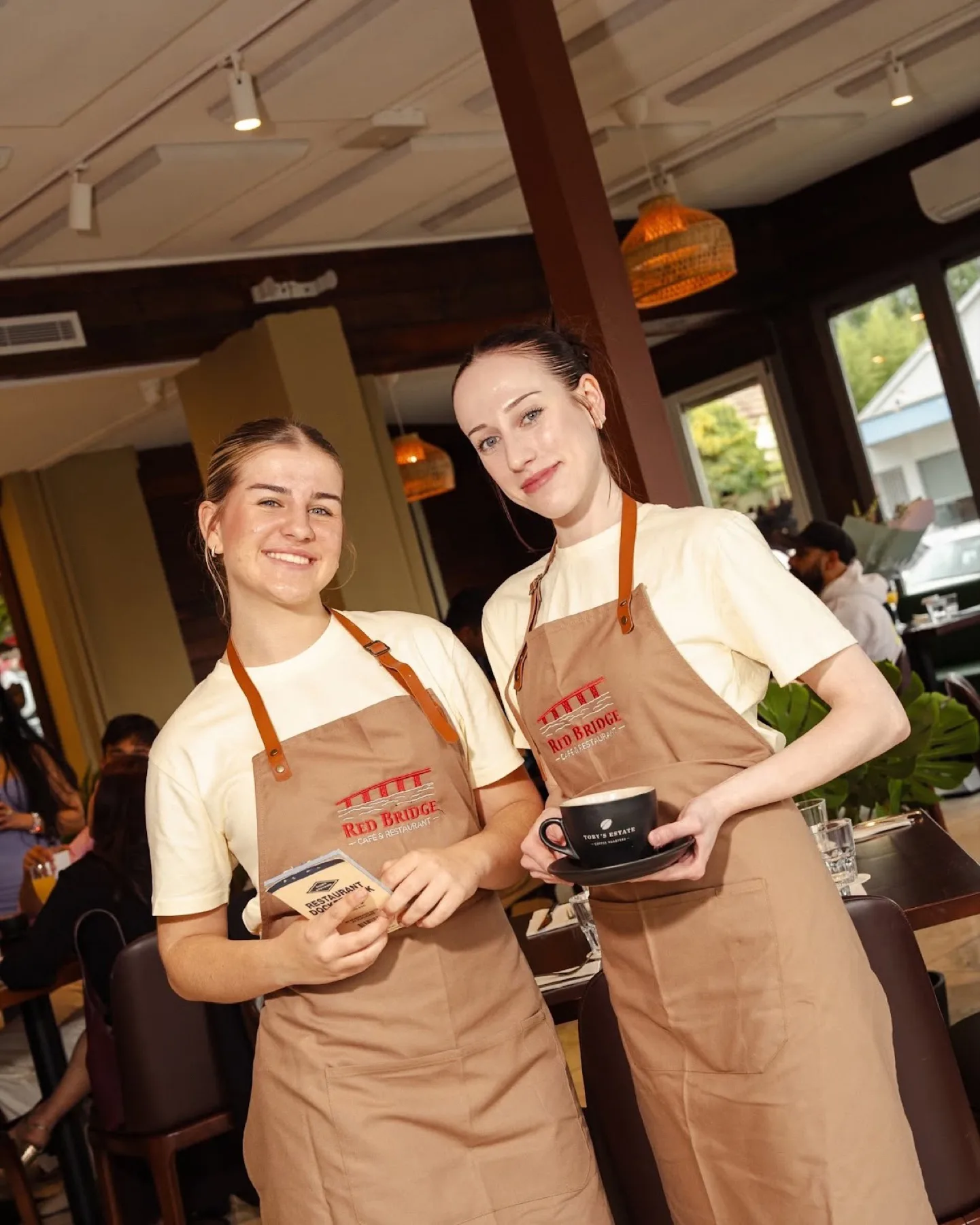 Two baristas sharing a laugh over coffee